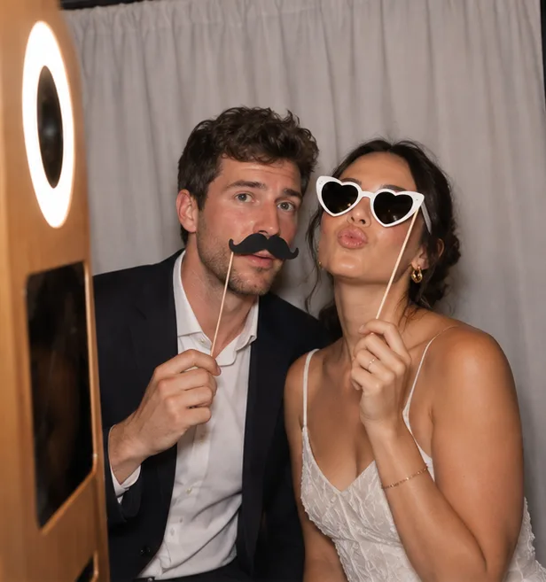 Un couple pose avec une moustache et des lunettes cœur